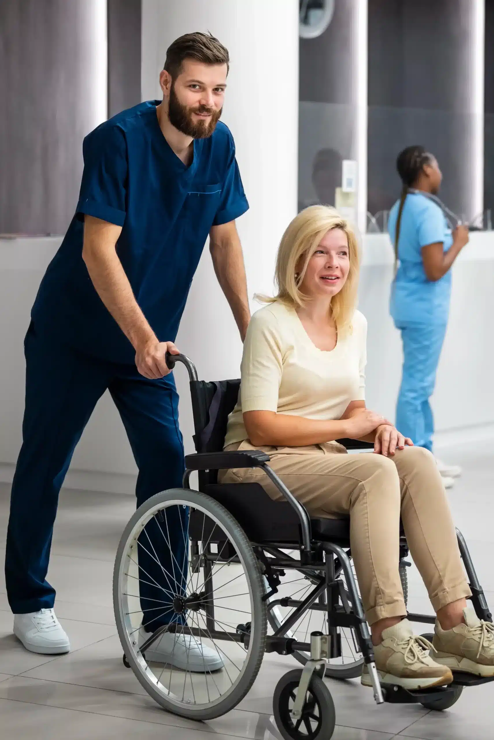 Soignant accompagnant personne en fauteuil roulant